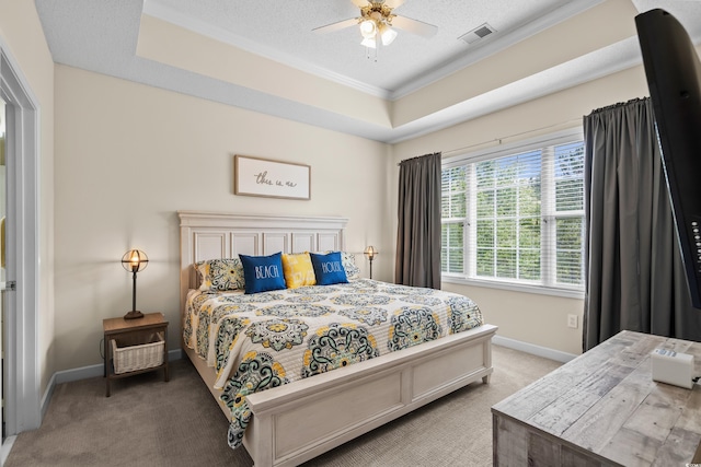 bedroom featuring crown molding, light colored carpet, baseboards, a tray ceiling, and a textured ceiling