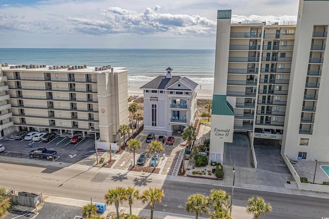view of apartment building / complex featuring a water view and uncovered parking