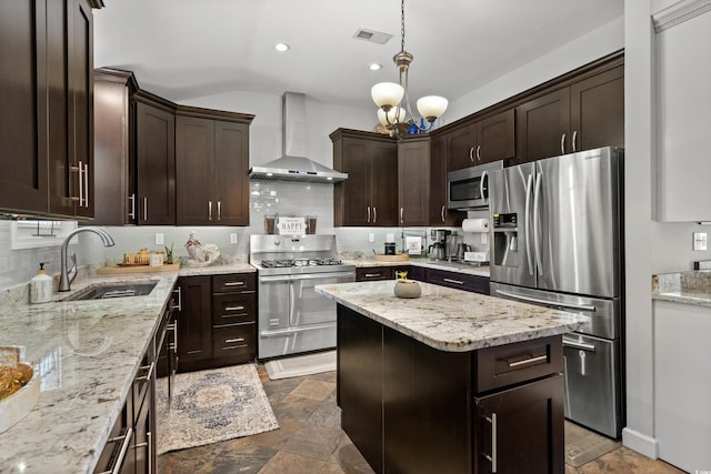 kitchen with stainless steel appliances, wall chimney exhaust hood, a sink, dark brown cabinetry, and tasteful backsplash