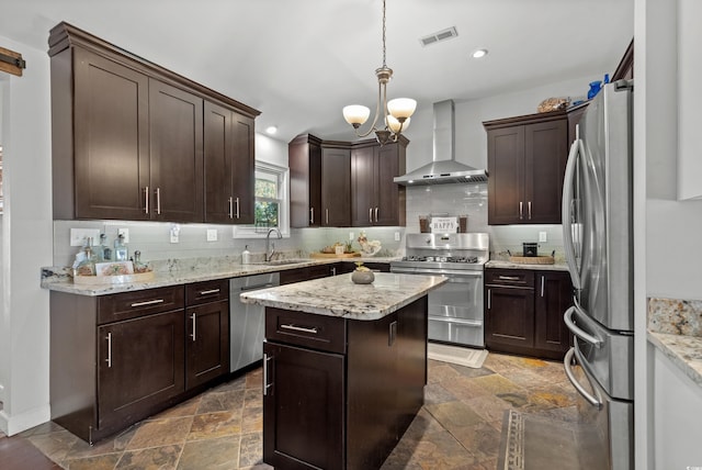 kitchen featuring wall chimney exhaust hood, stainless steel appliances, dark brown cabinetry, tasteful backsplash, and recessed lighting