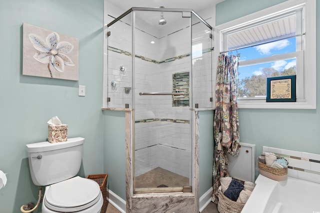 bathroom featuring toilet, a stall shower, baseboards, and a tub to relax in