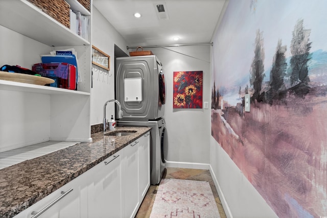 710 Yucca Ave, Myrtle Beach, SC 29577 - laundry area featuring stacked washer / dryer, cabinet space, light stone finish floors, and baseboards