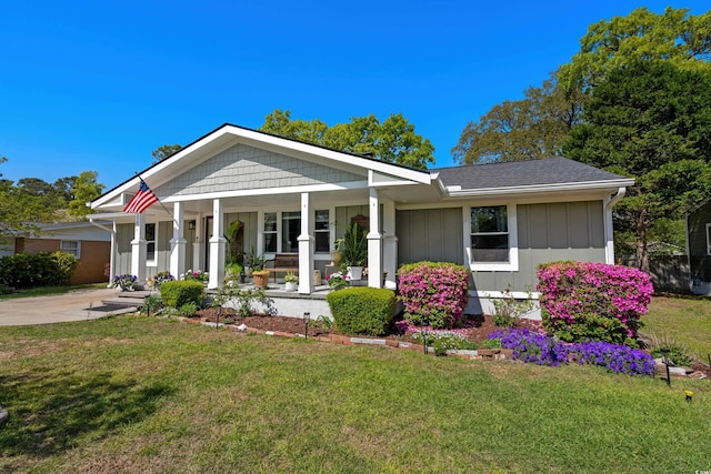 view of front of home featuring a porch, a front lawn, and board and batten siding
