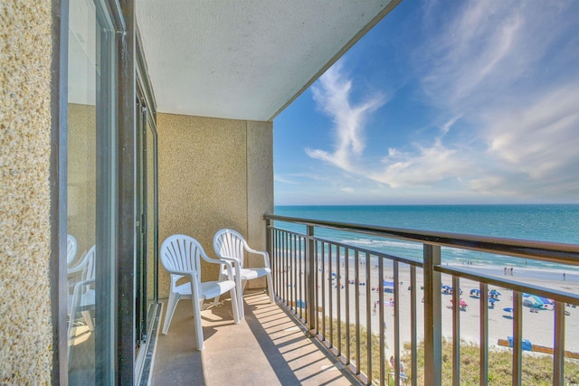 balcony featuring a beach view and a water view