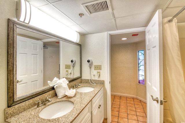 bathroom featuring a sink, tile patterned floors, double vanity, and visible vents