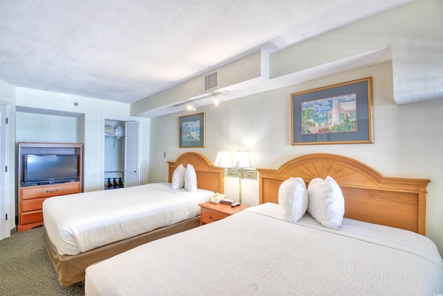 bedroom with rail lighting, visible vents, and a closet
