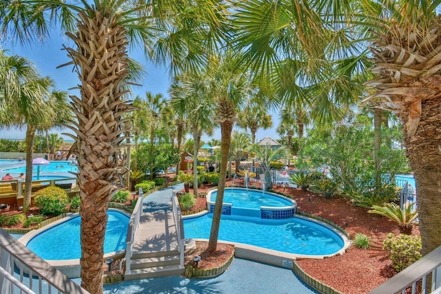 view of pool with a pool with connected hot tub and fence