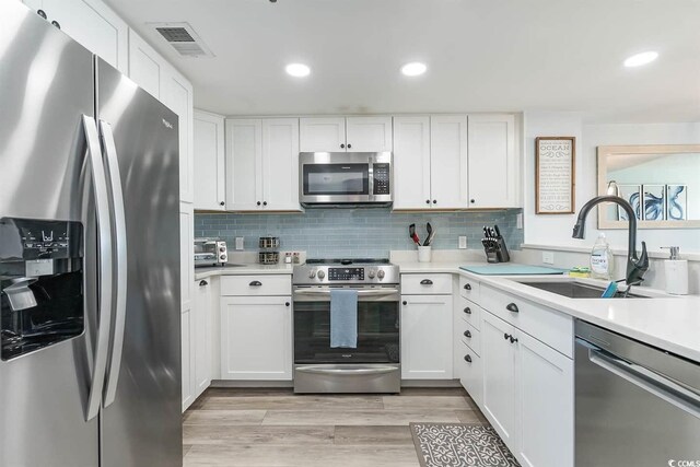 6100 N Ocean Blvd Unit 804, North Myrtle Beach, SC 29582 - kitchen featuring stainless steel appliances, light countertops, white cabinetry, light wood-type flooring, and recessed lighting