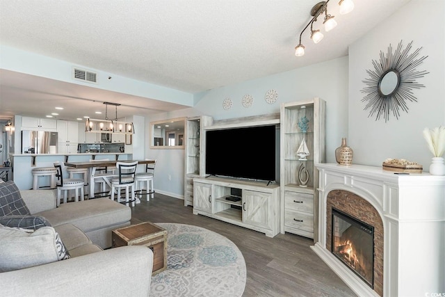 6100 N Ocean Blvd Unit 804, North Myrtle Beach, SC 29582 - living area featuring dark wood-style floors, a glass covered fireplace, and a textured ceiling