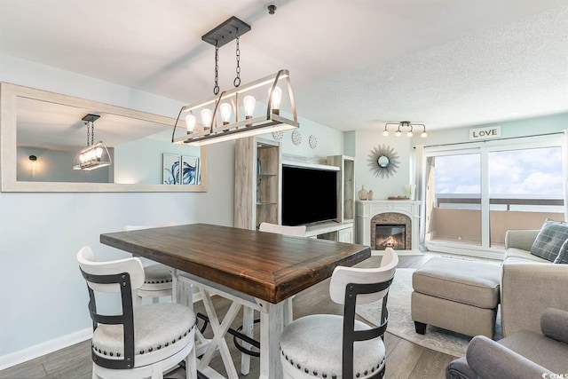 6100 N Ocean Blvd Unit 804, North Myrtle Beach, SC 29582 - dining room featuring wood finished floors, baseboards, and a glass covered fireplace