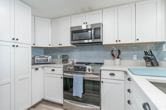6100 N Ocean Blvd Unit 804, North Myrtle Beach, SC 29582 - kitchen with appliances with stainless steel finishes, light countertops, white cabinetry, and decorative backsplash