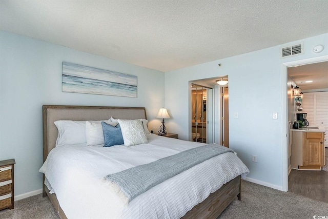 6100 N Ocean Blvd Unit 804, North Myrtle Beach, SC 29582 - bedroom featuring carpet floors, baseboards, ensuite bathroom, and a textured ceiling