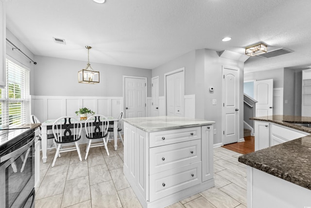 356 Whipple Run Loop, Myrtle Beach, SC 29588 - kitchen with stainless steel electric stove, white cabinets, a chandelier, dark stone countertops, and hanging light fixtures
