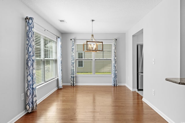 356 Whipple Run Loop, Myrtle Beach, SC 29588 - unfurnished dining area featuring a chandelier, wood finished floors, and a textured ceiling