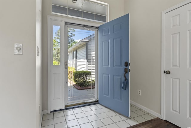 foyer with light tile patterned floors and baseboards