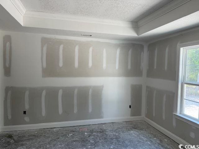unfurnished room featuring a textured ceiling, ornamental molding, and baseboards