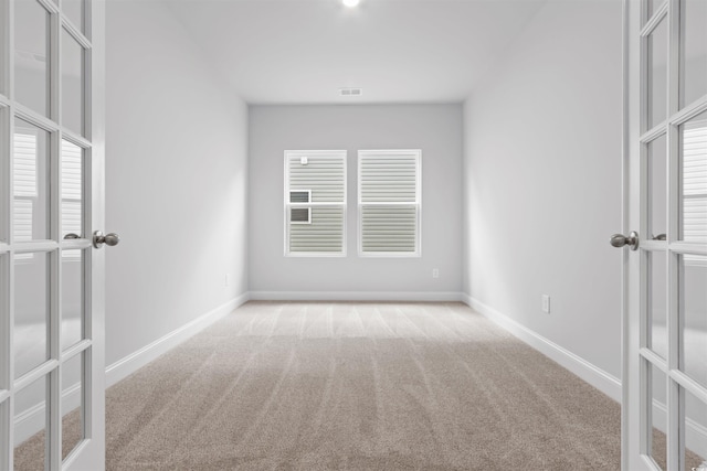 carpeted spare room featuring baseboards