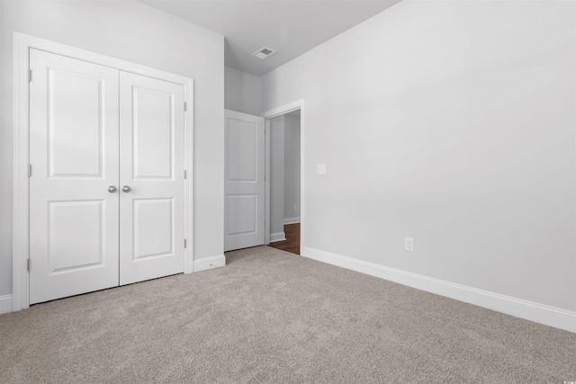 unfurnished bedroom with carpet flooring, a closet, and baseboards