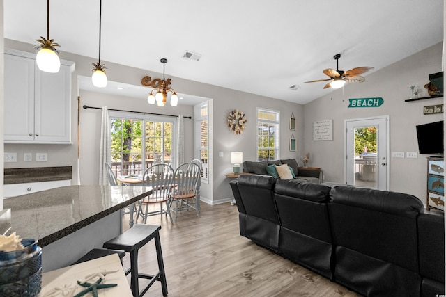6001-8050 S Kings Hwy, Myrtle Beach, SC 29575 - living room with ceiling fan with notable chandelier, light wood-style flooring, baseboards, lofted ceiling, and visible vents