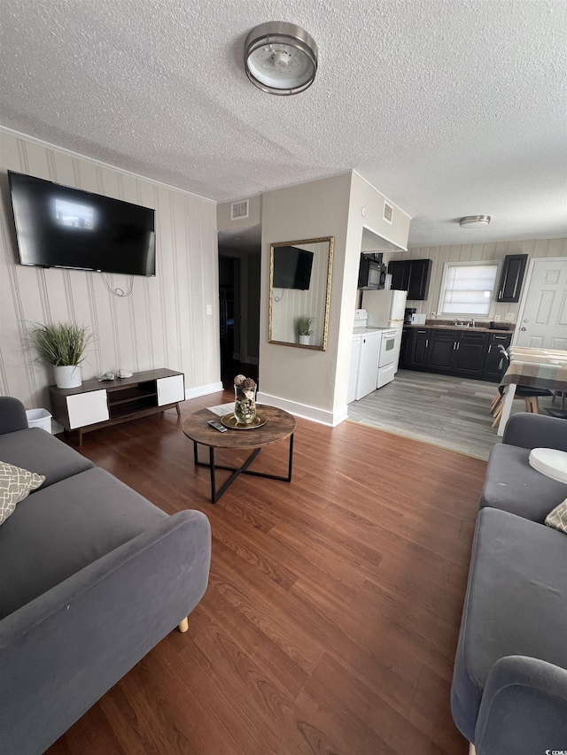706 Mitchell Dr, Myrtle Beach, SC 29577 - living room featuring a textured ceiling, light wood-type flooring, and baseboards