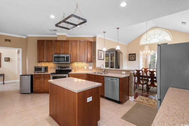 kitchen featuring arched walkways, an inviting chandelier, a sink, appliances with stainless steel finishes, and a peninsula