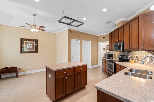 kitchen featuring stainless steel appliances, baseboards, a sink, and a kitchen island