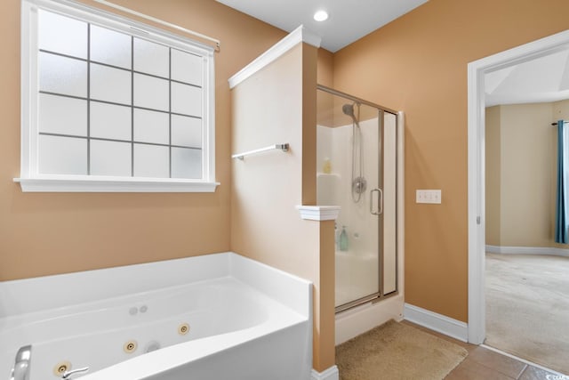 full bathroom featuring tile patterned floors, a shower stall, a tub with jets, and baseboards