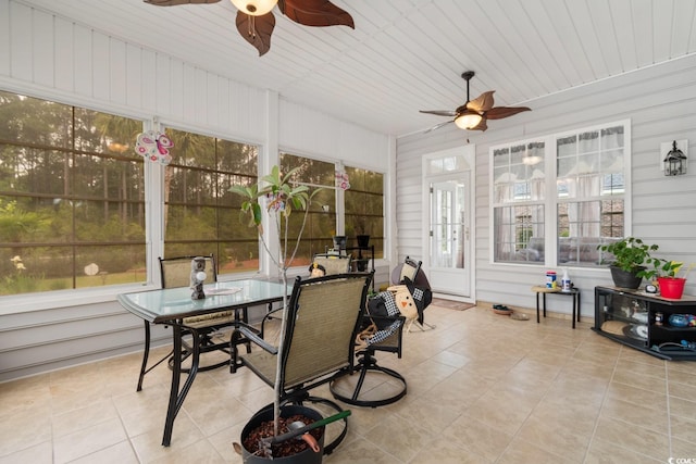 sunroom with french doors, tile patterned floors, outdoor dining space, and ceiling fan