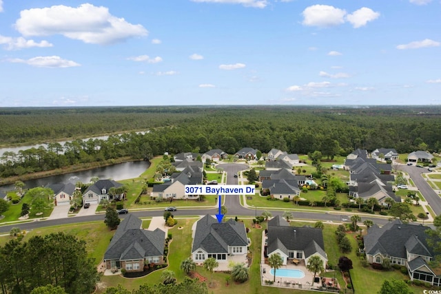aerial view featuring a wooded view, a residential view, and a water view