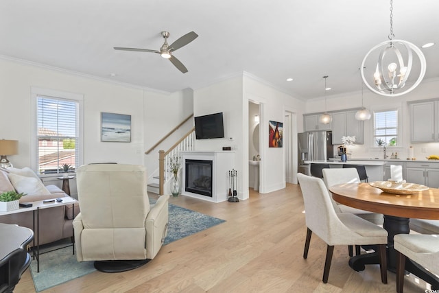 dining room featuring ceiling fan with notable chandelier, recessed lighting, light wood-style floors, and ornamental molding