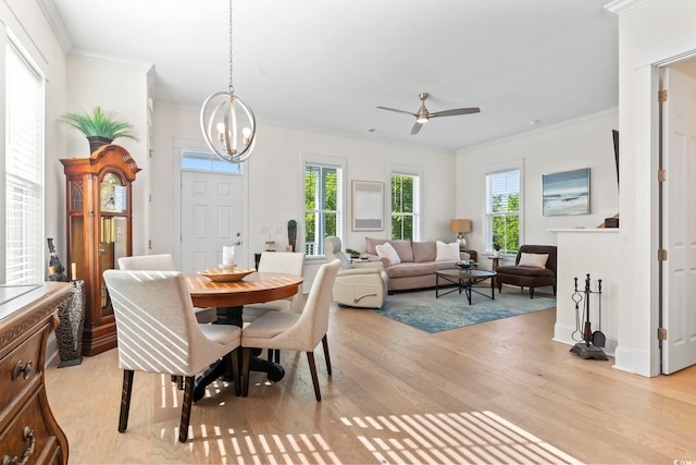 dining space featuring ceiling fan with notable chandelier, plenty of natural light, and crown molding