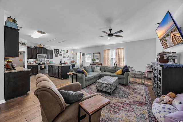 living room with light wood-type flooring and a ceiling fan