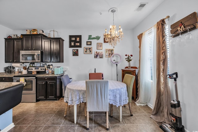 dining area with visible vents, tile patterned flooring, and an inviting chandelier