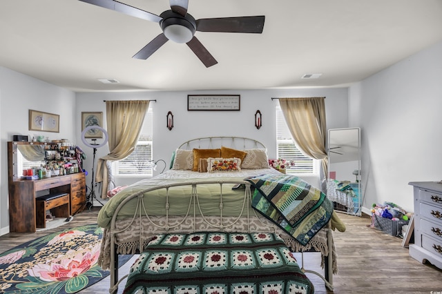 bedroom featuring wood finished floors, multiple windows, and visible vents