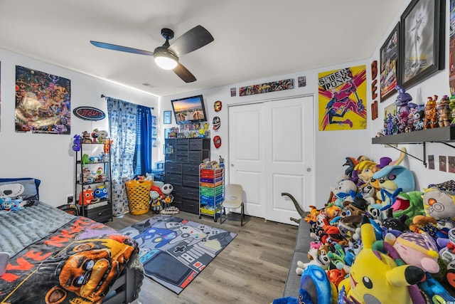 bedroom featuring a closet, wood finished floors, visible vents, and a ceiling fan