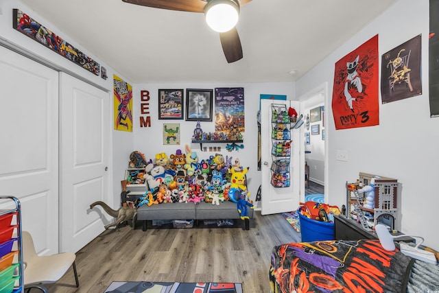 bedroom with ceiling fan, wood finished floors, and a closet