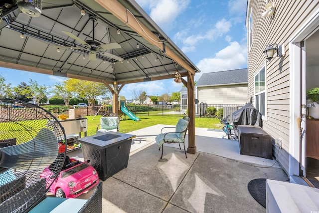view of patio with a fenced backyard, a playground, and ceiling fan