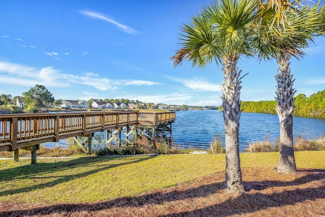 view of dock featuring a water view and a yard
