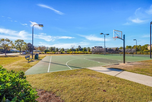 view of basketball court with a yard, community basketball court, and fence