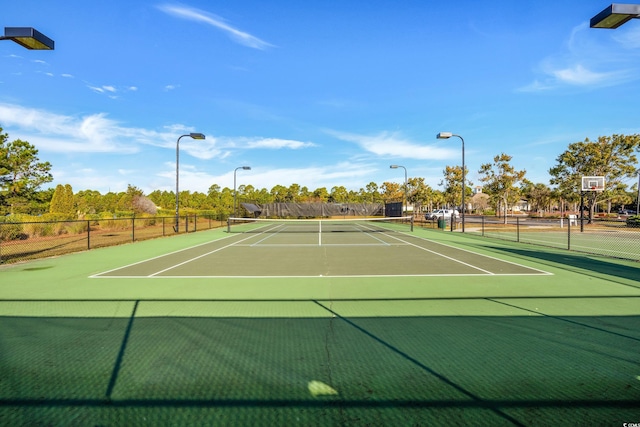 view of tennis court with fence and community basketball court