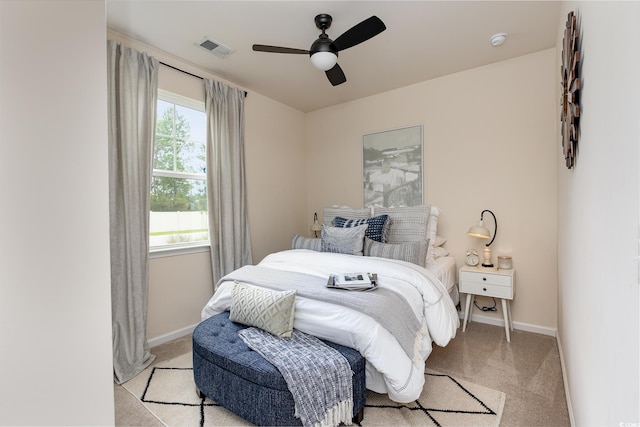 bedroom with a ceiling fan, visible vents, light carpet, and baseboards