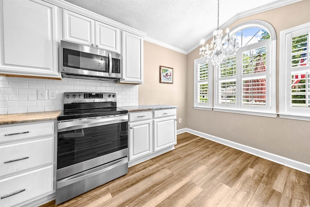 1516 Saint George Ln, Myrtle Beach, SC 29588 - kitchen featuring crown molding, light wood finished floors, a healthy amount of sunlight, and stainless steel appliances