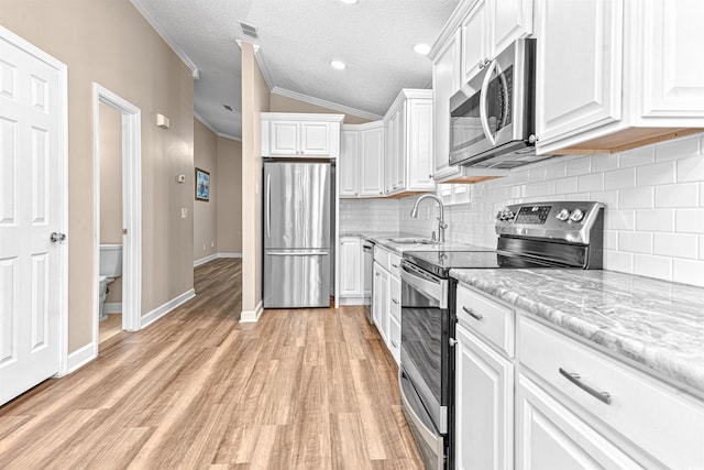 1516 Saint George Ln, Myrtle Beach, SC 29588 - kitchen with crown molding, stainless steel appliances, white cabinetry, and a sink