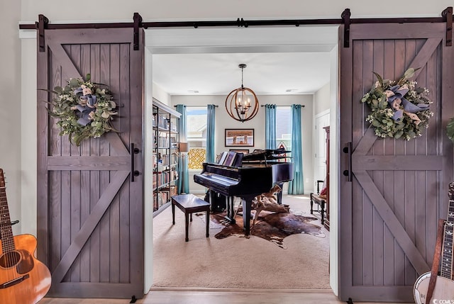 living area with a barn door, wood finished floors, and an inviting chandelier