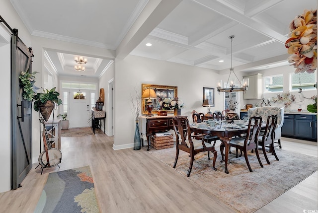 dining room featuring a barn door, an inviting chandelier, beamed ceiling, and light wood-type flooring