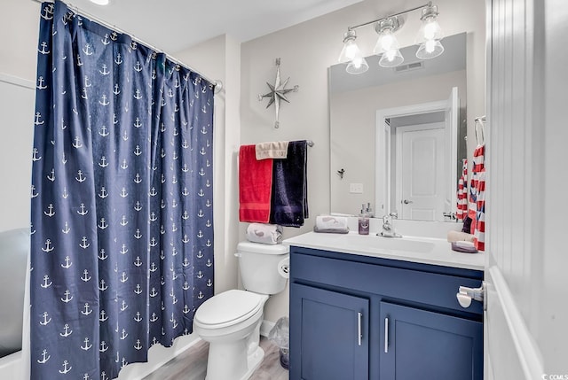 full bathroom featuring toilet, vanity, wood finished floors, and visible vents