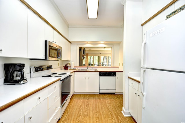 kitchen with white appliances, light wood finished floors, white cabinets, light countertops, and ornamental molding