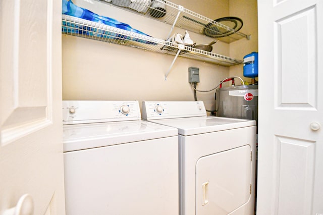 laundry room with independent washer and dryer and water heater