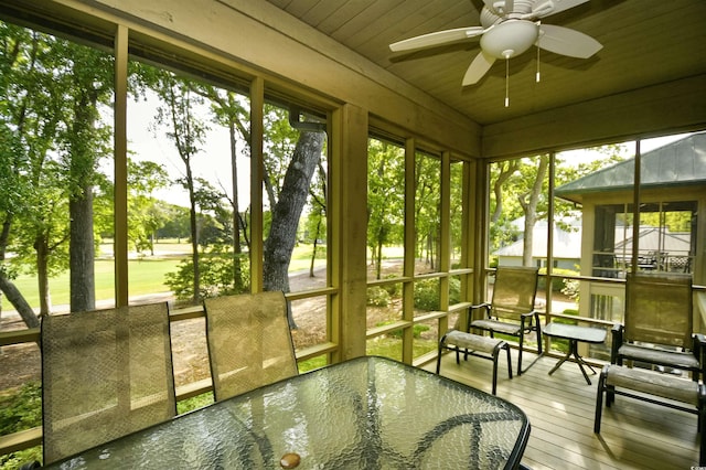 sunroom with a ceiling fan, plenty of natural light, and outdoor dining space