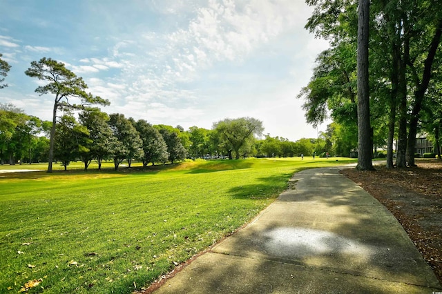 view of property's community with a lawn and view of scattered trees